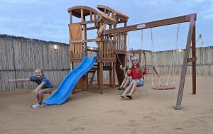 MarghamMargham Desert Safari Camp的两个孩子在沙滩上玩