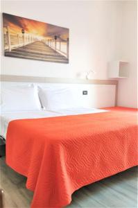 利尼亚诺萨比亚多罗西奥住宿加早餐旅馆的卧室配有红色的床,墙上挂有绘画作品