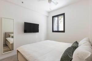 特拉维夫Eclectic Vision by TLV2RENT的白色卧室配有床和镜子