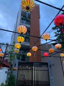 胡志明市LUCY HOTEL & APARTMENT的一群橙色和黄色的伞,挂在一座建筑上