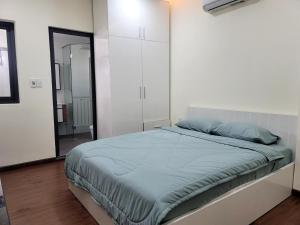 胡志明市LUCY HOTEL & APARTMENT的一间卧室配有床和白色橱柜