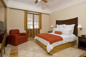 普拉亚卡门哈斯恩达日德尔卡日贝酒店的一间卧室配有一张大床和一张红色椅子