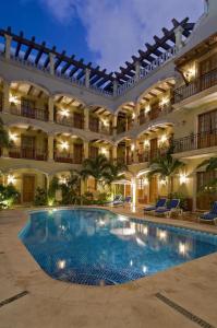 普拉亚卡门哈斯恩达日德尔卡日贝酒店的一座大建筑,在庭院里设有一个游泳池