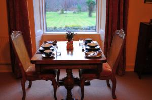 威廉堡Achintee Farm Guest House的餐桌、椅子和窗户