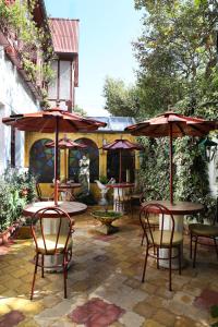 基多Boutique Hotel Antinea的一个带桌椅和遮阳伞的户外庭院。