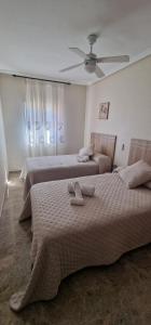 科尔多瓦Apartamento Ribera Real II的一间卧室配有两张床和吊扇