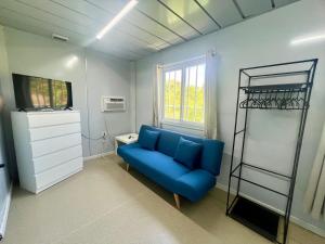 Cedar GroveGrace Container homes的客厅设有蓝色的沙发和架子