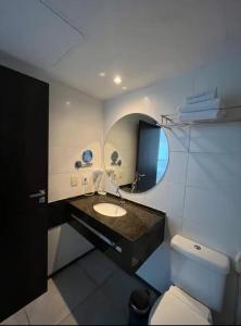 马塞约Suíte 511, do Hotel Ritz Suítes的一间带水槽、卫生间和镜子的浴室