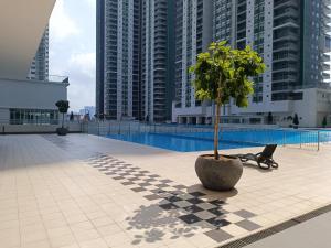吉隆坡Razak City Centre KL SkyView 45th的庭院里高大的建筑中一棵树