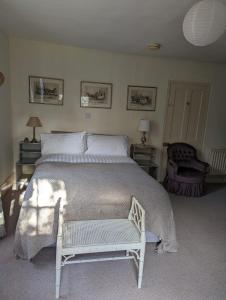 谢珀顿Old Manor House的一间卧室配有一张大床和一把椅子