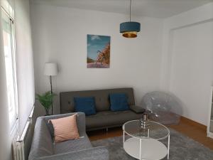 洛格罗尼奥Céntrico apartamento reformado de dos habitaciones的带沙发和玻璃桌的客厅