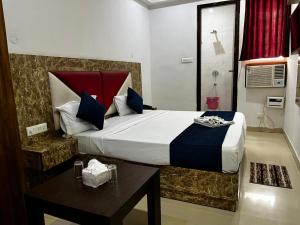 新德里wide Hotel的一间卧室配有一张大床和一张桌子