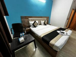 新德里wide Hotel的一间卧室配有一张床、一把椅子和一张桌子