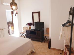 ZagaroloIl Ninfeo " le cocon" appartamento的一间卧室配有一张床、一台电视和一面镜子