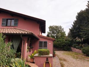 ZagaroloIl Ninfeo " le cocon" appartamento的粉红色的房子,有一条通往房子的通道