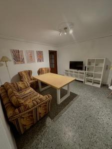 塞维利亚Apartamento en Sevilla的客厅配有桌子和沙发