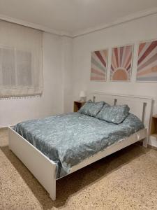 塞维利亚Apartamento en Sevilla的白色卧室配有蓝色床单