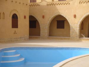 Az ZabūEl Beyt Farmhotel的一座带房子的建筑中的游泳池