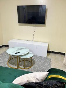 基苏木Art’s Suites的客厅配有桌子,墙上配有电视