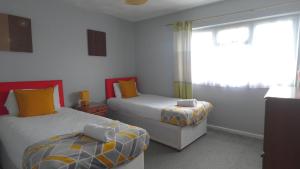 Houghton RegisEddiwick House - Huku Kwetu Dunstable -Spacious 3 Bedroom House- Sleeps 6 - Suitable & Affordable Group Accommodation - Business Travellers的一间卧室设有两张床和窗户。