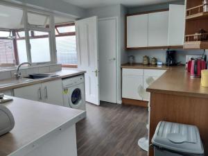 Houghton RegisEddiwick House - Huku Kwetu Dunstable -Spacious 3 Bedroom House- Sleeps 6 - Suitable & Affordable Group Accommodation - Business Travellers的厨房配有白色橱柜和洗衣机。