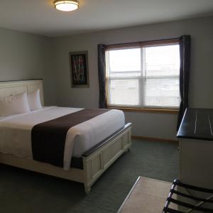 迪格比码头边套房宾馆的一间卧室设有一张大床和一个窗户。