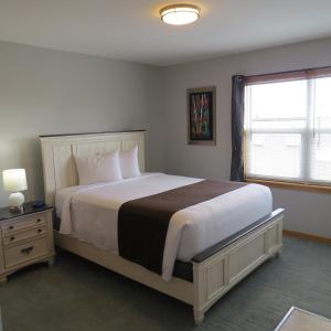 迪格比码头边套房宾馆的一间卧室设有一张大床和一个窗户。
