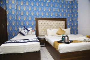 商沙巴Hotel MN Grand Shamshabad Airport Zone Hyderabad的酒店客房设有两张床和蓝色的墙壁。