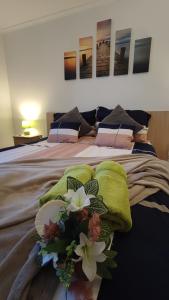 加尔多尼Limonádé Apartman的一张带绿毯和鲜花的床