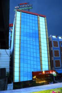 商沙巴Hotel MN Grand Shamshabad Airport Zone Hyderabad的一座大型玻璃建筑,上面有标志