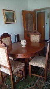 热那亚Terrazza sul mare citra 1666的木制餐桌,配有椅子和碗