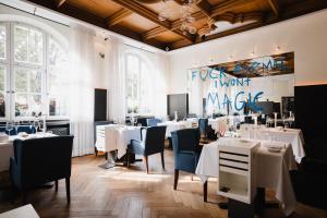 维尔斯贝格Posthotel Alexander Herrmann的餐厅设有白色的桌子和蓝色的椅子