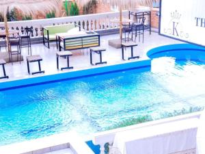 基加利KEZA Home的餐厅旁的游泳池配有桌椅