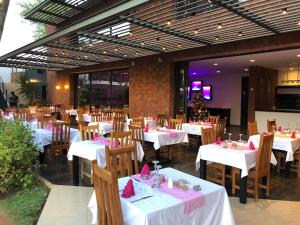 Sali PoulangKEPARANGA的餐厅配有白色的桌椅和粉红色的餐巾