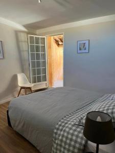 莱德农Maison de village的卧室配有床、椅子和窗户。