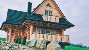 斯扎法拉瑞Jedlinowo Chata Domek Góralski的小木屋设有绿色屋顶和阳台