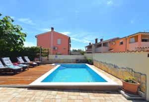巴尔巴里加Ferienhaus mit Privatpool für 6 Personen ca 80 qm in Barbariga, Istrien Istrische Riviera的一个带木制甲板的庭院内的游泳池
