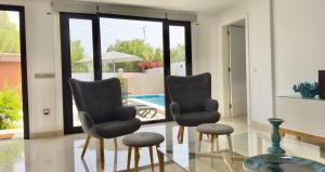 圣克鲁斯-德特内里费Apartamento Tenerife Vista Bella的一个带游泳池的房间里设有两把椅子和一张桌子