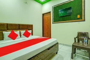 KurukshetraOYO Hotel Patiala的卧室配有一张床铺,墙上配有电视