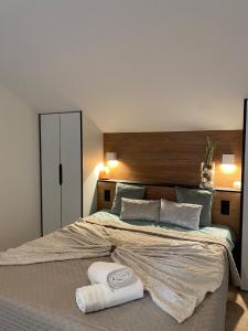 帕艾维坡斯特Maison Paray- Orly- Parking Privé的一间卧室配有一张大床和两条毛巾