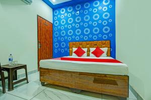 KurukshetraOYO Hotel Patiala的一间卧室配有一张蓝色墙壁的床