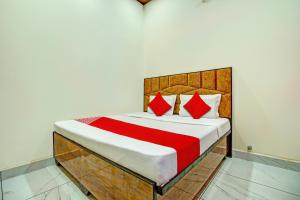 KurukshetraOYO Hotel Patiala的一间卧室配有一张带红色枕头的大床