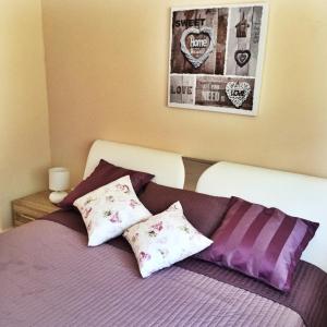 巴登-巴登甜蜜公寓 的一间卧室配有一张带紫色床单和枕头的床。
