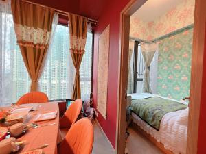 香港香港將軍澳歐式風格3房2廳高級公寓的卧室配有一张床和一张桌子及椅子