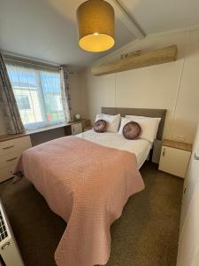 查珀尔圣伦纳兹Golden Palm Resort - The Twilight - Coastal Caravan Breaks的一间卧室配有一张带两个枕头的床