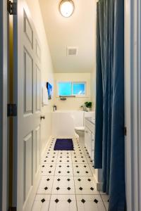 尤金Blue House - private 2 bed, 2 bath home with garage的浴室设有白色门和黑白瓷砖地板。