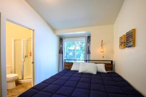 尤金Blue House - country living close to everything的一间卧室设有蓝色的床和窗户。