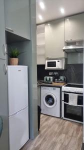 格拉斯哥Entire, lovely apartment with a bath tub的厨房配有白色冰箱和洗碗机。