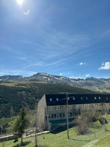 BrañaviejaApartamento en estación de esquí y montaña alto campoo的一座有雪覆盖的山丘的建筑
