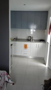 Mão para TrásCasa Mrichica的厨房配有白色橱柜和橙色毛巾